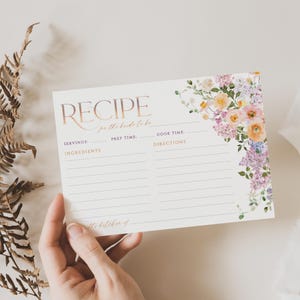 May include: A white recipe card with a floral border. The card has the words "RECIPE for the bride to be" at the top. The card has sections for servings, ingredients, prep time, cook time, and directions.