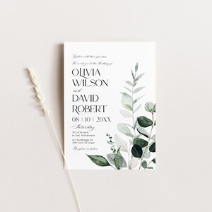 May include: A wedding invitation with a watercolor design of eucalyptus leaves in shades of green and white. The invitation text reads "Together with their families, we invite you to the wedding of Olivia Wilson and David Robert, 08 | 10 | 20XX, Saturday, at 3 o'clock in the afternoon, 123 Anywhere St., Any City, ST 12145, Reception to follow."