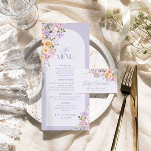 May include: A purple and white wedding menu card with floral illustrations. The menu includes appetizers, main course, beverages, and desserts. The text on the card reads "The Menu", "Appetizer", "Main Course", "Beverages", "Desserts", "Jessica & Richard", and "12.12.20XX".