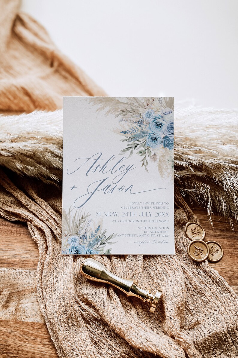 K&ouml;nnte beinhalten: Eine Hochzeitseinladung mit einem Aquarelldesign mit blauen Blumen und Pampasgras. Die Einladung lautet "Ashley + Jason" und enth&auml;lt das Datum "Sonntag, 24. Juli 20XX".