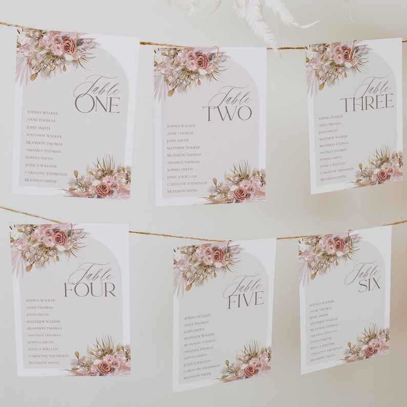 May include: Six printable table cards with floral designs and the words "Table One", "Table Two", "Table Three", "Table Four", "Table Five", and "Table Six". Each card has a list of names for guests.