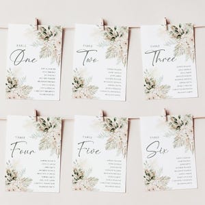 Puede incluir: Seis tarjetas de n&uacute;mero de mesa con un dise&ntilde;o floral de acuarela en tonos verdes y beige. Cada tarjeta tiene un n&uacute;mero de mesa escrito en cursiva negra y una lista de nombres debajo.