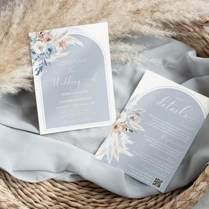May include: Two wedding invitations with a blue and white floral design. The top invitation says "The Wedding of" and the bottom invitation says "The Details".