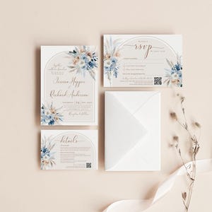 May include: A wedding stationery set featuring an invitation, RSVP card, and details card, all adorned with blue and beige floral illustrations and arched frames. A white envelope and a dried floral stem are included in the arrangement.