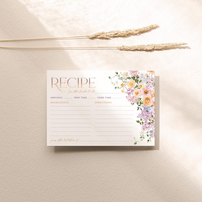 May include: A white recipe card with a floral design in shades of pink, purple, and yellow. The card has the words "Recipe for the bride to be" printed on it, along with sections for serving size, prep time, cook time, ingredients, and directions.