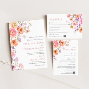 May include: A wedding invitation suite featuring a main invitation, a reply card, and a details card. Each white card displays pink text and watercolor floral illustrations in shades of pink, orange, and purple. A thin, light-colored twig lies across the bottom.
