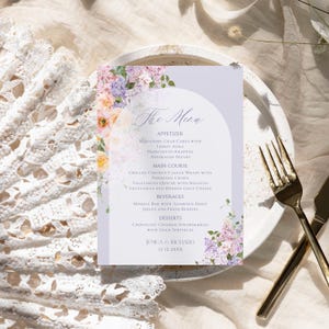 May include: A wedding menu card with a floral design. The menu includes appetizers, main course, beverages, and desserts. The text on the card reads "The Menu", "Miniature Crab Cakes with Lemon Aioli", "Prosciutto-Wrapped Asparagus Spears", "Grilled Chicken Caesar Wraps with Parmesan Crisps", "Vegetarian Quiche with Roasted Vegetables and Herbed Goat Cheese", "Mimosa Bar with Assorted Fruit Juices and Fresh Berries", "Chocolate Covered Strawberries with Gold Sprinkles", "Jesica & Richard", "12.12.20XX".