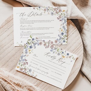 May include: A floral wedding RSVP card with a white background and a border of blue and purple flowers. The text on the card reads "Kindly Reply by August 27th".