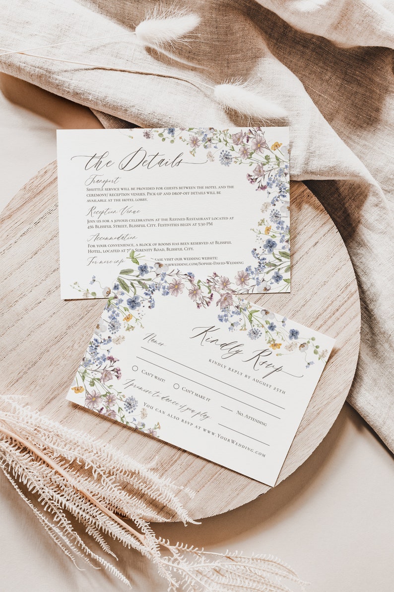 May include: A floral wedding RSVP card with a white background and a border of blue and purple flowers. The text on the card reads "Kindly Reply by August 27th".