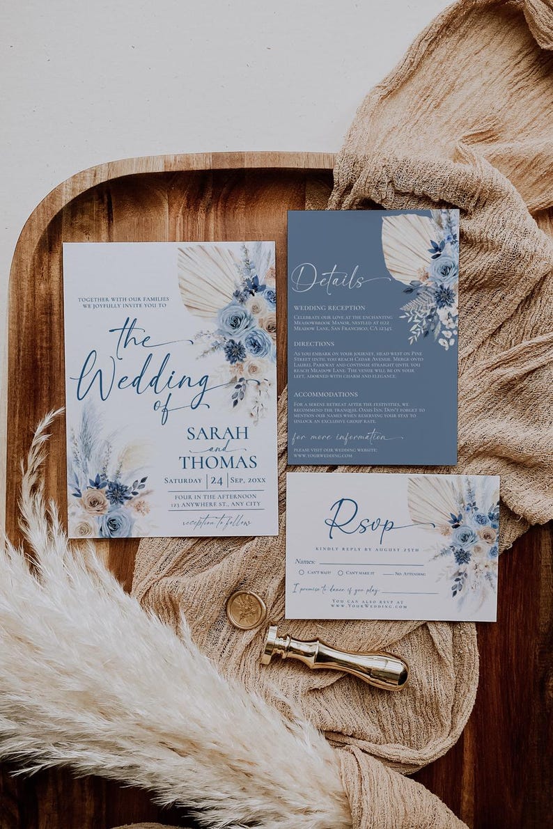 May include: A wedding invitation suite with a blue and beige color scheme. The invitation features a floral design with pampas grass and the text "The Wedding of Sarah and Thomas". The details card includes information about the wedding reception and directions. The RSVP card has a place for guests to indicate their attendance.
