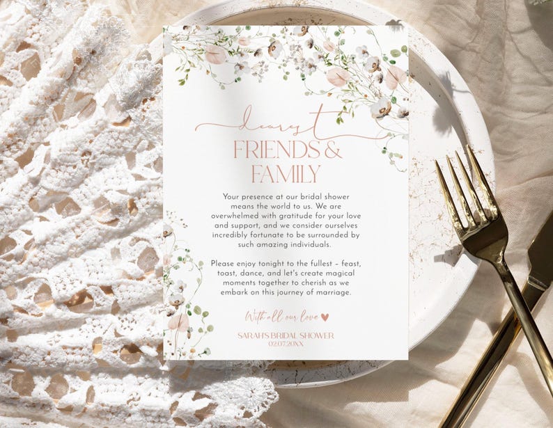 May include: A rectangular white card featuring a floral border of pink and green watercolor flowers. The text reads: dearest FRIENDS & FAMILY. Your presence at our bridal shower means the world to us. SARAH'S BRIDAL SHOWER 02.07.20XX.