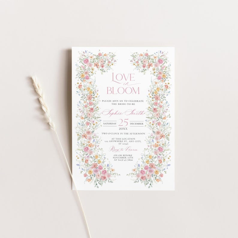 May include: A white invitation card with a floral border and the text "Love in Bloom." The card includes details for a wedding celebration, with the date, time, and location. The floral border features pink, yellow, and green flowers.