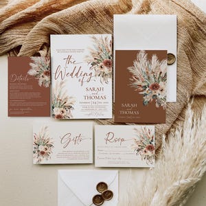 K&ouml;nnte beinhalten: Eine Hochzeitseinladungssuite im Boho-Stil. Die Einladung zeigt ein florales Design mit Pampasgras und einem braunen Hintergrund. Der Text lautet "The Wedding of Sarah and Thomas, Saturday, 24 Sep, 20XX, Four in the afternoon, Anywhere, Any City".