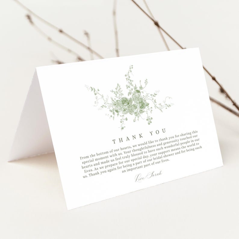 May include: White folded thank you card with a floral design in shades of green. The card features the words "THANK YOU" at the top, with a message below. The card is blank inside.