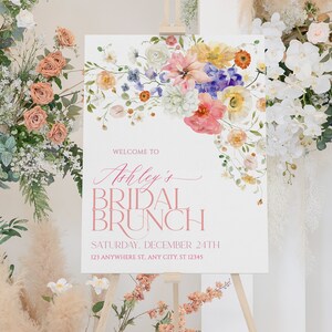 Pu&ograve; includere: Un cartello bianco con un disegno floreale in alto. Il cartello dice "Benvenuti al Brunch Nuziale di Ashley" e include la data e l'indirizzo.