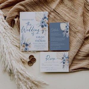 May include: Wedding invitation suite with a blue and white floral design. The invitation features the text "The Wedding of Sarah and Thomas" with the date "Saturday 24 Sep 20XX". The RSVP card includes the text "Rsop" and a space for guests to RSVP by August 20XX.