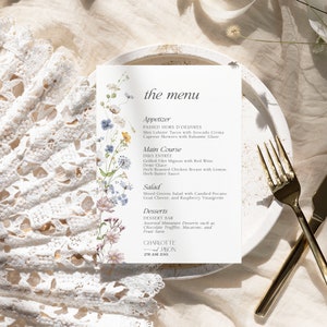 K&ouml;nnte beinhalten: Eine Hochzeitsmen&uuml;karte mit floralem Design. Das Men&uuml; umfasst Vorspeisen, Hauptgericht, Salat und Desserts. Der Text auf der Karte lautet "the menu", "Appetizer", "Passed Hors d'oeuvres", "Mini Lobster Tacos with Avocado Crema", "Caprese Skewers with Balsamic Glaze", "Main Course", "Duo Entree", "Grilled Filet Mignon with Red Wine Demi-Glace", "Herb Roasted Chicken Breast with Lemon Herb Butter Sauce", "Salad", "Mixed Greens Salad with Candied Pecans, Goat Cheese, and Raspberry Vinaigrette", "Desserts", "Dessert Bar", "Assorted Miniature Desserts such as Chocolate Truffles, Macarons, and Fruit Tarts", "Charlotte Jason 27th June 20XX".