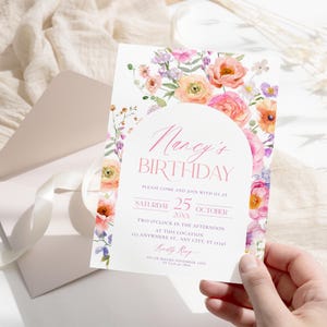 May include: A floral birthday invitation with a pink and white color scheme. The invitation features a watercolor floral design with a pink arch and the text "Nancy's Birthday". The invitation also includes the date and time of the event, as well as the location.
