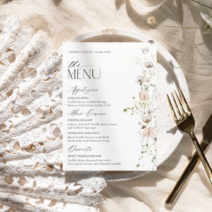 May include: A white rectangular menu card with black text and a floral illustration on the right side. The text reads SOPHIE & DAVID | 10.08.20XX, THE MENU, Appetizers, Main Course, and Desserts, followed by specific food items.