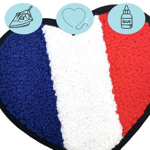 Puede incluir: Un parche termoadhesivo en forma de coraz&oacute;n con los colores de la bandera francesa: azul, blanco y rojo. Las instrucciones para aplicar el parche se muestran en la imagen: planchar o pegar.