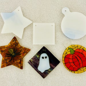 May include: A set of ten blank, white, ceramic ornaments in various shapes, including a star, a circle, a square, and a pumpkin. The ornaments are ready to be painted or decorated.