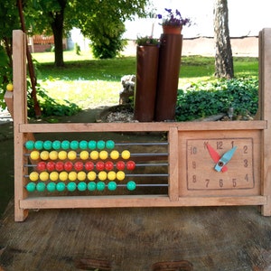 50–60 Jahre alter Vintage-Abakus aus Holz mit bunten Kunststoffperlen und Uhr – klassisches Lernwerkzeug und dekoratives Stück aus der Mitte des Jahrhunderts