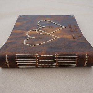 May include: A brown leather-bound journal with two stitched hearts and the text "5 Years Together" and "Diane & Zoran" on the cover.