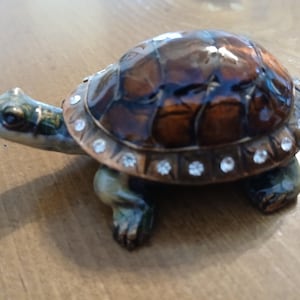 May include: A set of three ceramic mugs with a speckled, matte finish. The mugs are in shades of cream, light gray, and dark gray. Each mug has a simple, minimalist design, perfect for coffee or tea.