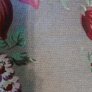May include: Close-up of a fabric with a floral pattern. The design features large, stylized flowers in shades of red, pink, and purple against a textured grey background. The text "&copy; 1986 PEARCE INCORPORATED" is printed at the top.