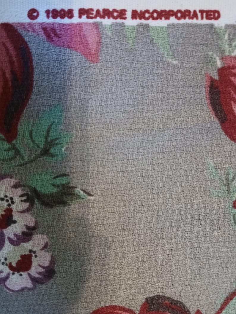 May include: Close-up of a fabric with a floral pattern. The design features large, stylized flowers in shades of red, pink, and purple against a textured grey background. The text "&copy; 1986 PEARCE INCORPORATED" is printed at the top.