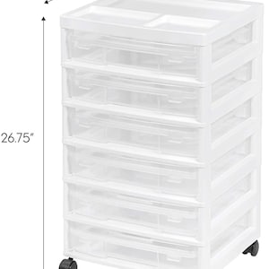 May include: White plastic 6-drawer rolling storage cart with clear drawers. The cart measures 14.25 inches wide, 15.88 inches deep, and 26.75 inches tall.