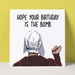 May include: A birthday card with the message "HOPE YOUR BIRTHDAY IS THE BOMB". The illustration shows a person in a white bonnet and maroon clothing holding a small object. The background is white with a yellow border.