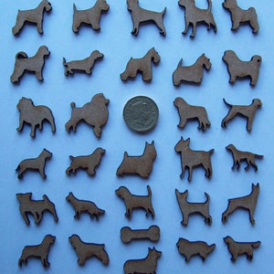 May include: A collection of 36 wooden dog silhouette cutouts in various breeds, including a dachshund, poodle, and terrier. The cutouts are arranged in rows on a light blue background.