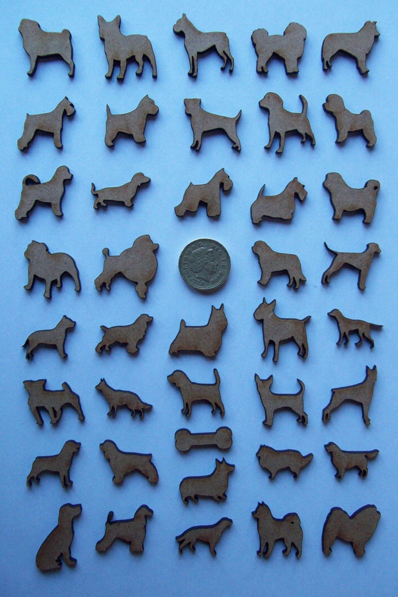 May include: A collection of 36 wooden dog silhouette cutouts in various breeds, including a dachshund, poodle, and terrier. The cutouts are arranged in rows on a light blue background.