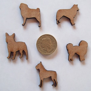 May include: Five wooden dog silhouette cutouts in various breeds. The cutouts are brown and are approximately the size of a UK one pound coin.