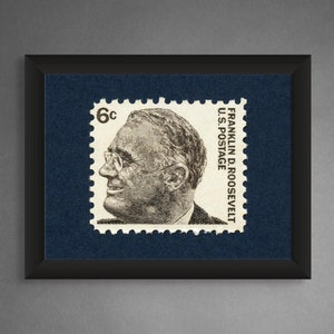 May include: A framed black and white stamp featuring a portrait of Franklin D. Roosevelt with the text "FRANKLIN D. ROOSEVELT U.S. POSTAGE 6c" printed on the stamp.
