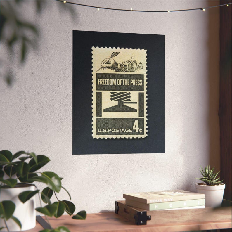 May include: A vintage US postage stamp with a black and white illustration of a hand writing with a quill pen. The stamp reads "Freedom of the Press" and "U.S. Postage 4&cent;".