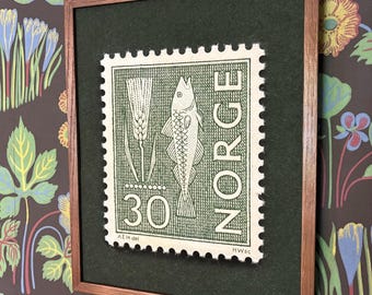 May include: A framed wall art piece featuring a vintage Norwegian postage stamp design. The stamp is cream-colored with dark green ink, depicting a fish, a stalk of grain, the number 30, and the text NORGE, all set against a dark green mat.