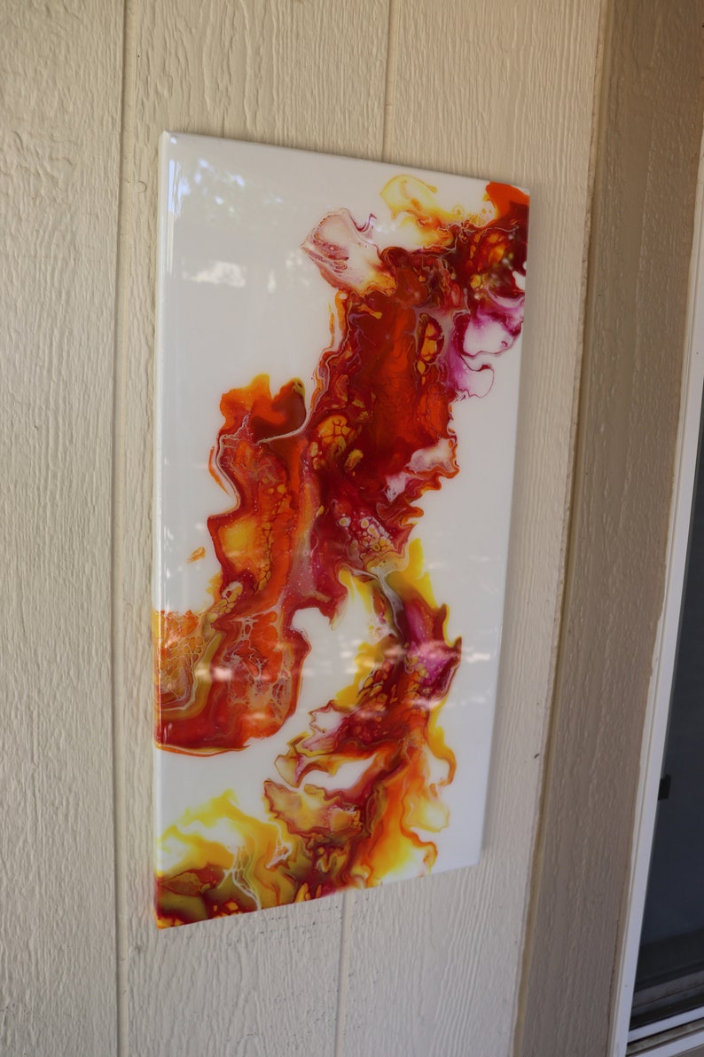 May include: Abstract painting with swirling patterns in shades of red, orange, yellow, and white on a white canvas.