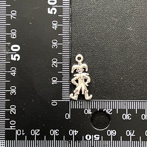 K&ouml;nnte beinhalten: Silberner Anh&auml;nger eines Narren mit spitzen Hut und Gl&ouml;ckchen. Der Anh&auml;nger ist etwa 2,5 cm hoch.