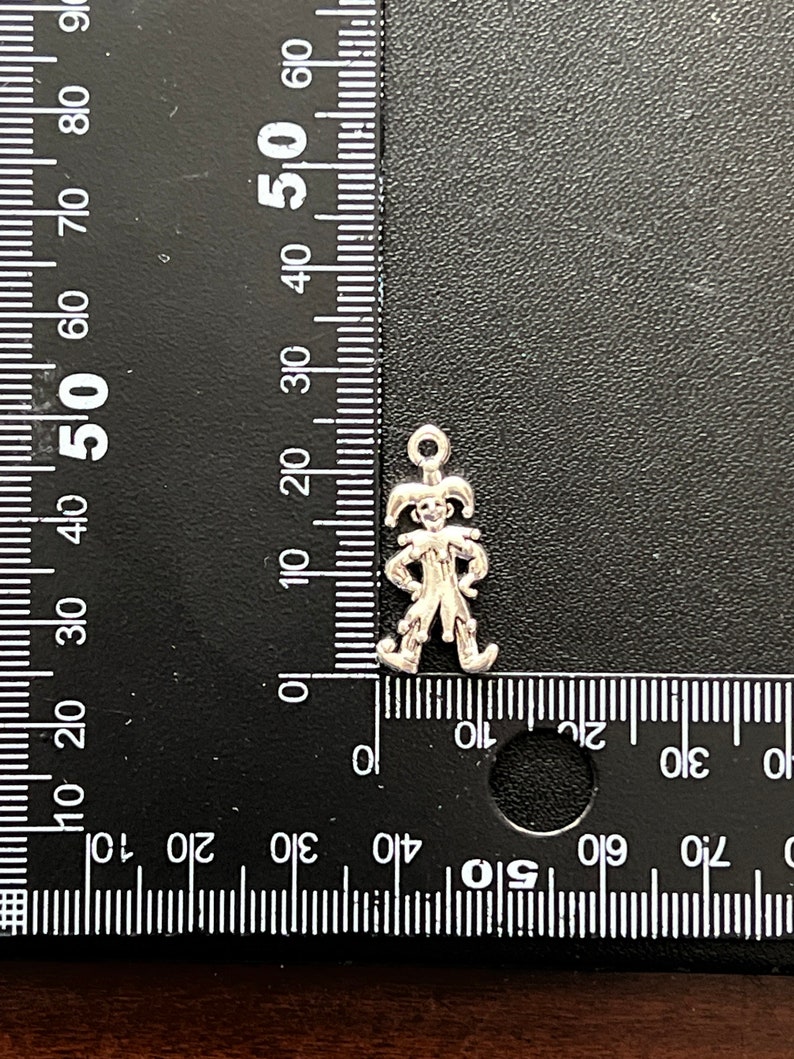 K&ouml;nnte beinhalten: Silberner Anh&auml;nger eines Narren mit spitzen Hut und Gl&ouml;ckchen. Der Anh&auml;nger ist etwa 2,5 cm hoch.