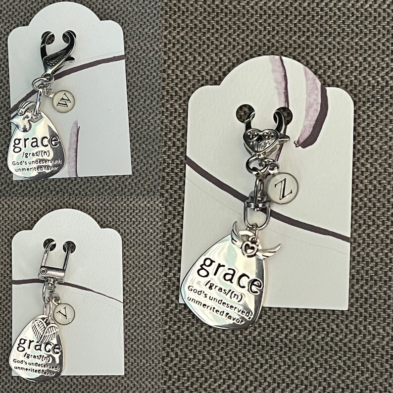 May include: Silver charm with a teardrop-shaped pendant that reads "grace /gras/(n) God's undeserved unmerited favor". The charm is attached to a silver key ring with a small silver heart and a letter "Z" charm.