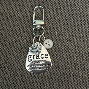 May include: Silver keychain with a charm that says "grace" and defines it as "God's undeserved, unmerited favor". The charm also has a small pair of angel wings.