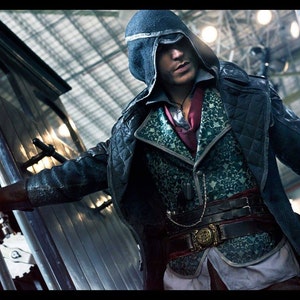 May include: A man in a hooded, black coat with a quilted lining and a patterned vest. He is wearing a belt with a buckle and a chain. The man is holding a metal rod in his right hand.