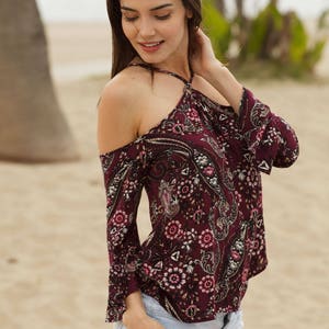 boho off the shoulder halter top with wooden trim accent. 3/4&quot; sleeve with ruffle at bottom of sleeve. Straps are adjustable