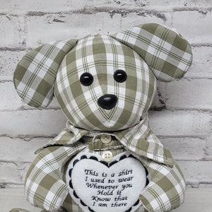 May include: A green and white plaid teddy bear with a heart-shaped patch that reads "This is a shirt I used to wear Whenever you Hold it Know that I am there". The bear's foot is embroidered with the word "Papa" and the dates "8/12/65" and "6/1/23".