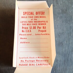 May include: A white paper order form with red text. The form is for a model kit of the Lotus-Ford Indianapolis 500 Mile Race Winner. The price is &pound;1.00 per kit. The form includes a space for the customer's name and address. The form also includes instructions to send cash, cheque, or money order. The form states that no postage is necessary and to please seal carefully.