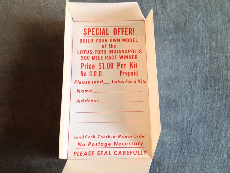 May include: A white paper order form with red text. The form is for a model kit of the Lotus-Ford Indianapolis 500 Mile Race Winner. The price is &pound;1.00 per kit. The form includes a space for the customer's name and address. The form also includes instructions to send cash, cheque, or money order. The form states that no postage is necessary and to please seal carefully.