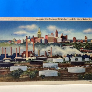 May include: A vintage postcard depicting an oil refinery and the Tulsa, Oklahoma skyline. The postcard features a colorful illustration of the refinery and the city's buildings, with smoke rising from the refinery's smokestacks.