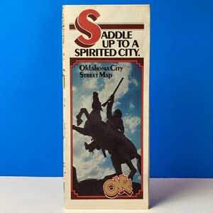 Puede incluir: Un mapa callejero vintage de Oklahoma City con una silueta de un vaquero montando un caballo. El mapa tiene el texto "Saddle Up To A Spirited City." y "Oklahoma City Street Map".